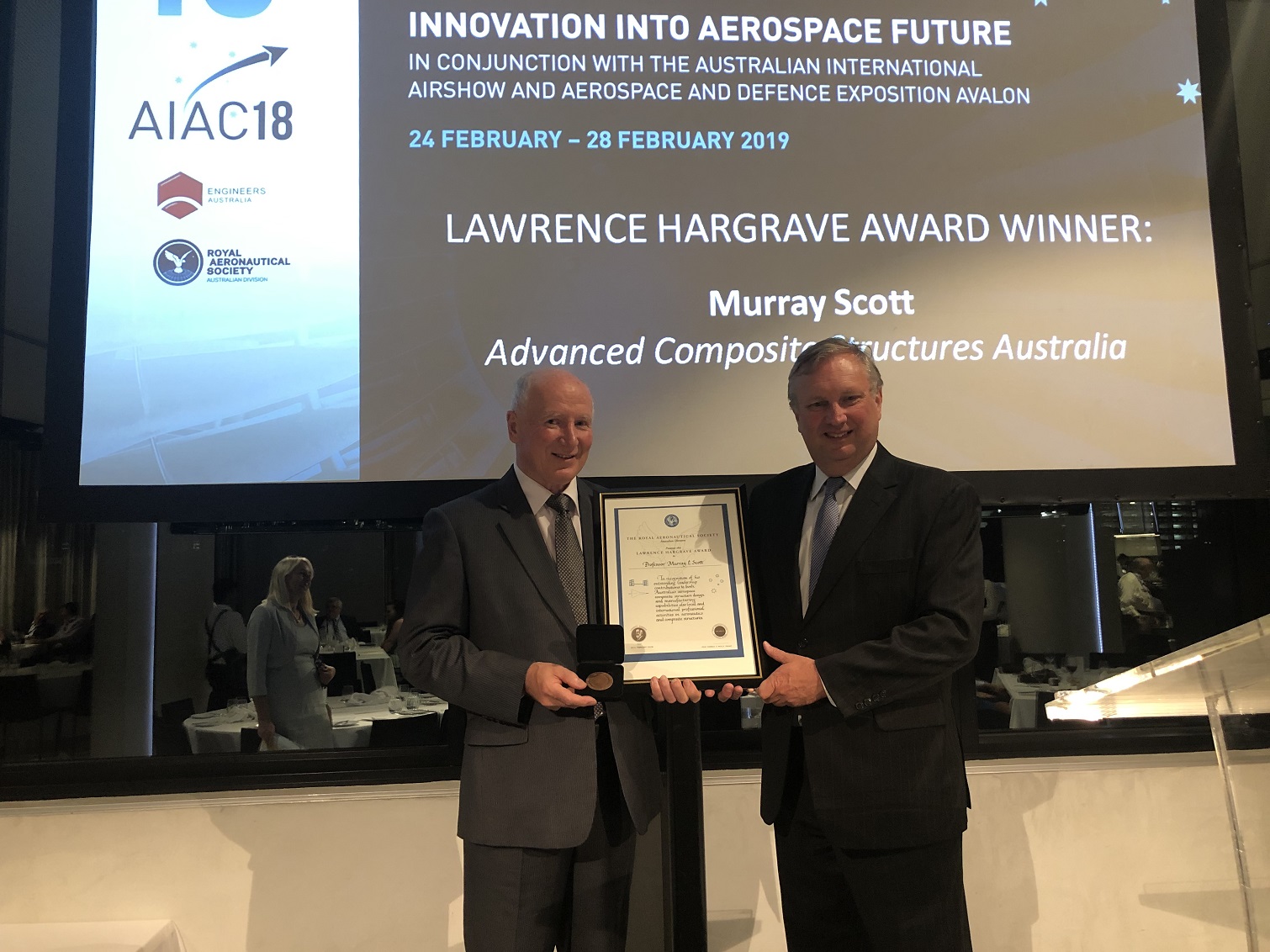 Professor Murray Scott stands with his award